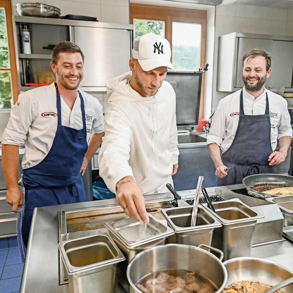 Schwört auf die Fleischlaberl seiner Mutter: Marko Arnautović mit Tamino (li.) und Fritz Grampelhuber in der Küche. © Steegwirt