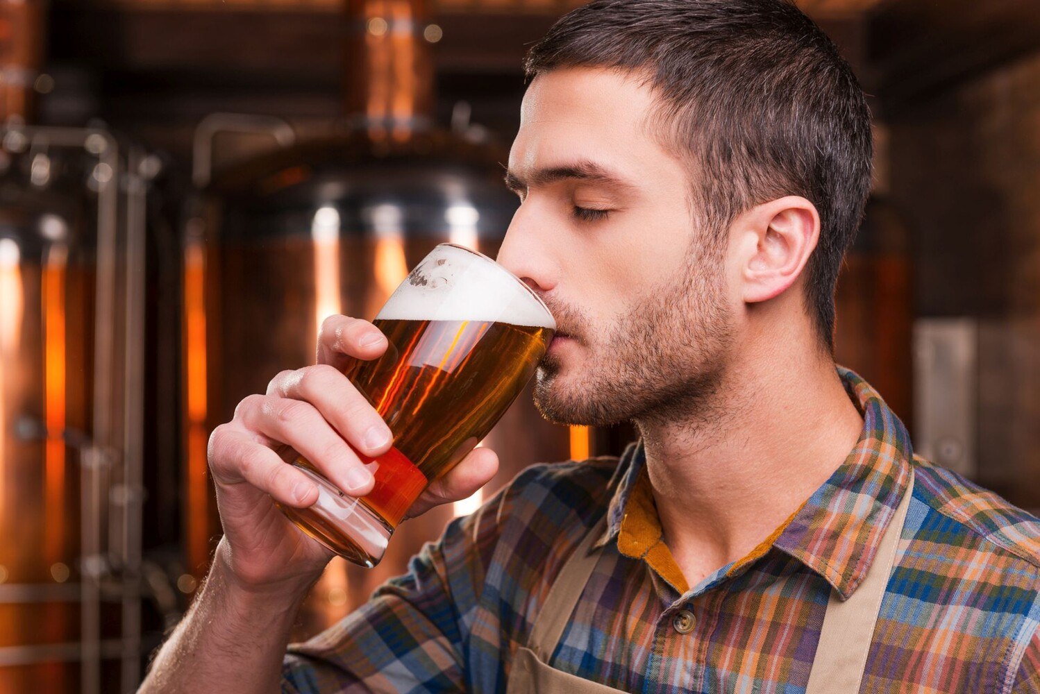 Da steht er, der junge Braumeister – Schürze stramm, Augen zu und Mund voll Bier. Inmitten seines Sudhauses testet er seine neueste Kreation. Kein offizielles Jury-Mitglied, aber wer braucht schon Titel, wenn man Geschmack hat? Wer weiß, vielleicht mischt er beim nächsten BeerTasting Community Award mit – als Genießer hat er ja schon mal das richtige Training. © iStock / Getty Images Plus / g-stockstudio