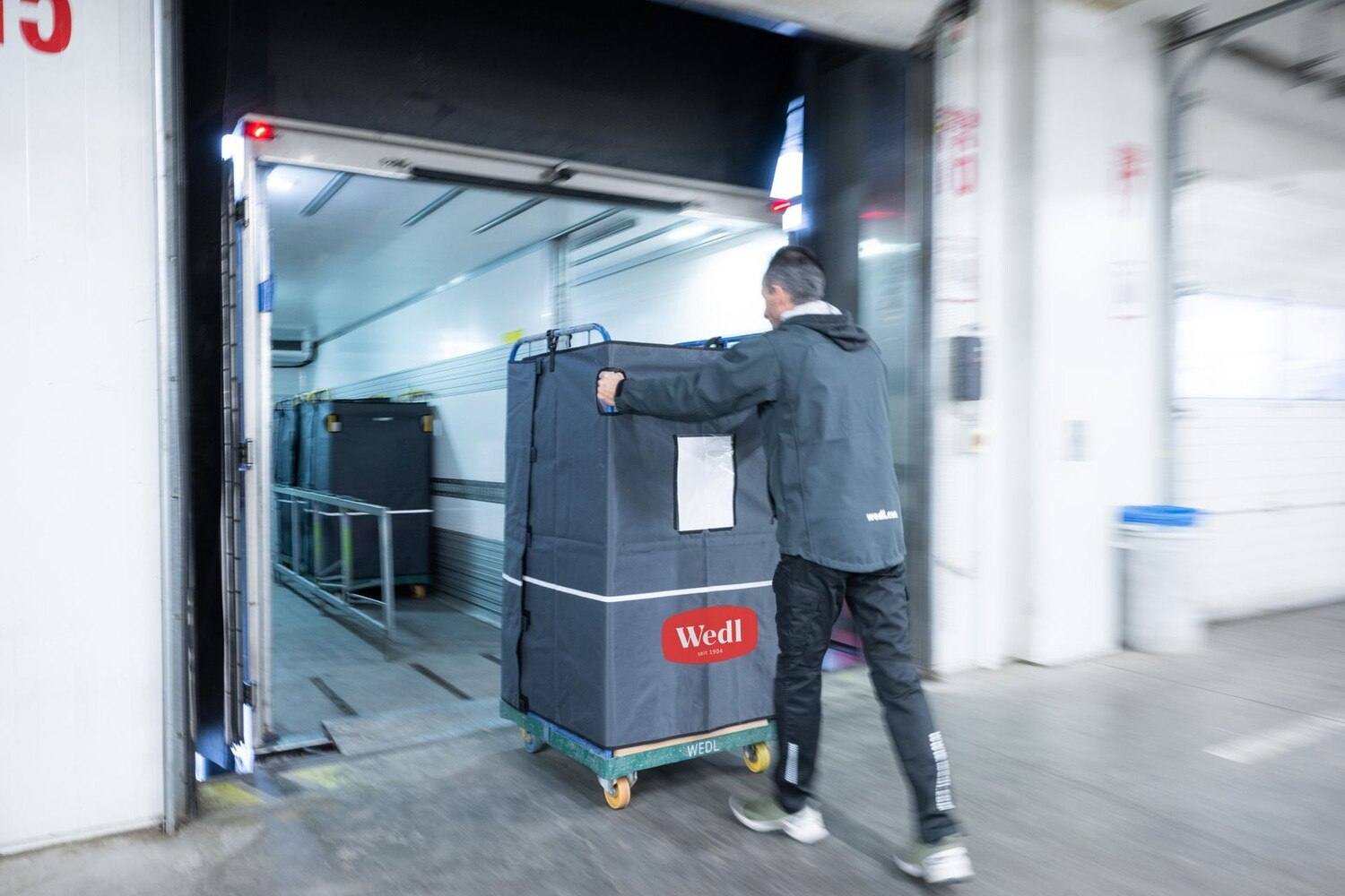 Clever: Durch die Verwendung von „RolliCoat“ - einer Mehrweg-Plane aus zertifiziertem Recyclingmaterial - müssen Rollcontainer nicht mehr mit Stretchfolie umwickelt werden. © Wedl / Franz Oss