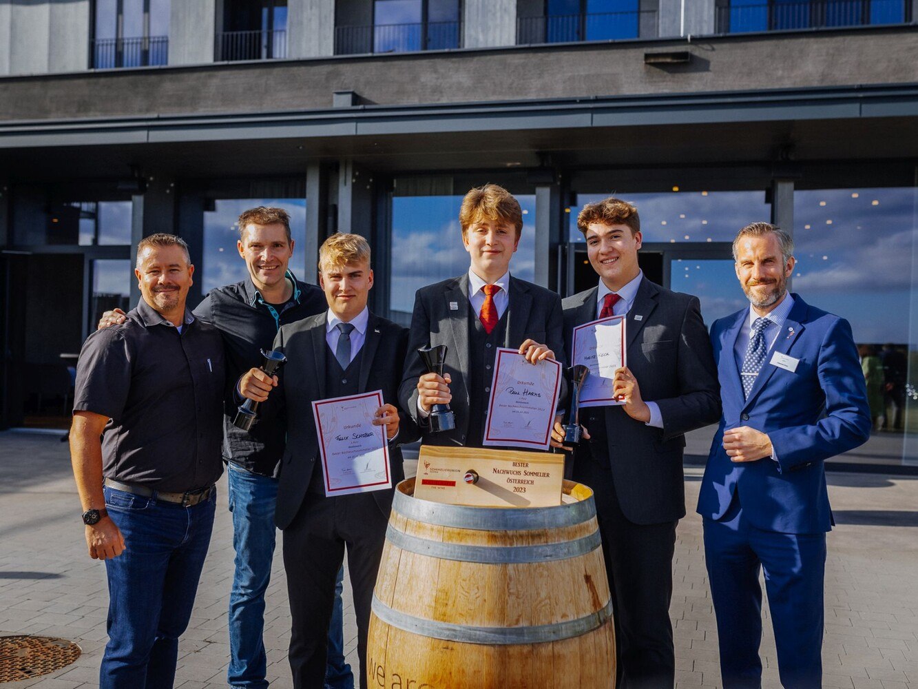 Siegerfoto des Wettbewerbs Bester Nachwuchssommelier Österreichs 2023. (v.l.) Brad Knowles, Vizepräsident Sommelier Union Austria; Erich Scheiblhofer, Winzer und Gastgeber des Wettbewerbs; Felix Schober, Zweitplatzierter; Paul Harms, Gewinner; Moritz Keck, Drittplatzierter; Philipp Künemund, Vizepräsident Deutsche Sommelier Union und Juryvorsitzender.
  © SUA / Christine Miess