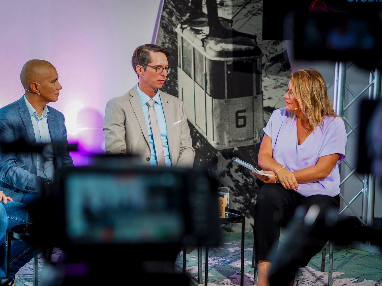 Patricio Hetfleisch (Marketingleiter Tirol Werbung, l.) und Philip Krammer (CEO Terawind) im Öko-Talk mit Moderatorin Verena Schneider. ©  Tiroler Zugspitz Arena