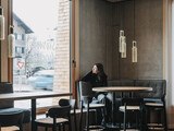 Eine Frau sitzt am Fenster in einem Restaurant.