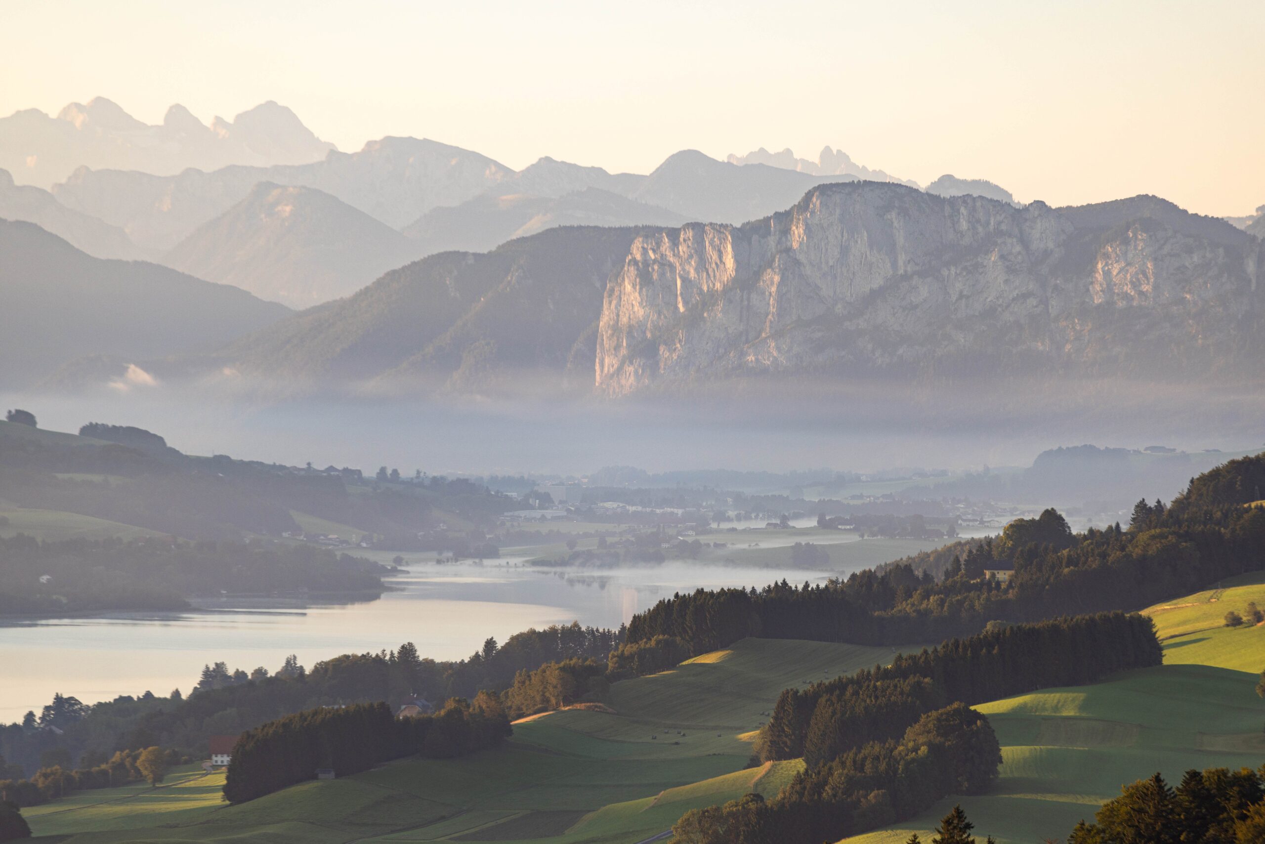 Landschaftsfoto zeigt Berge und Seen im Nebel.