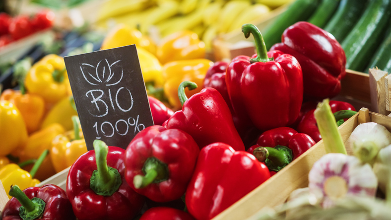 Gemüsekiste, gefüllt mit Paprika, hat ein Schild worauf BIO steht.